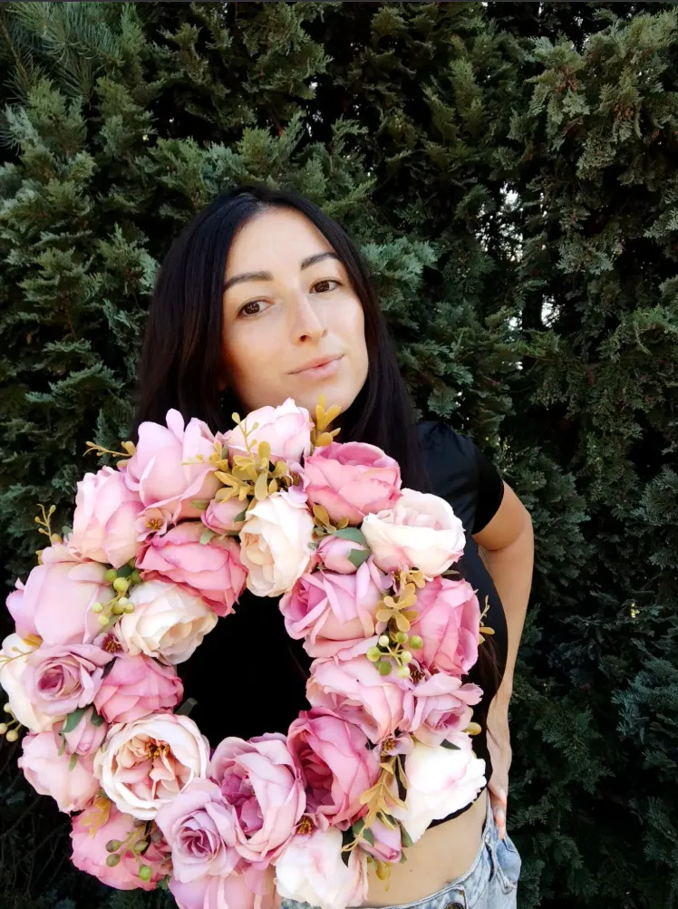 Sylwia trzyma okrągły wianek z różowych piwonii